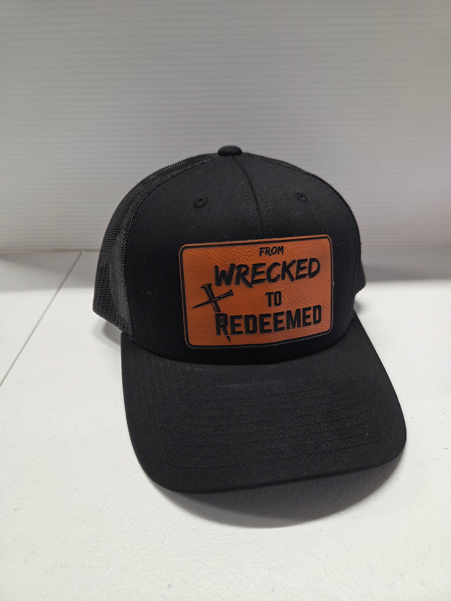 From Wrecked to Redeemed Black Yupoong hat with Orange laser engraved patch